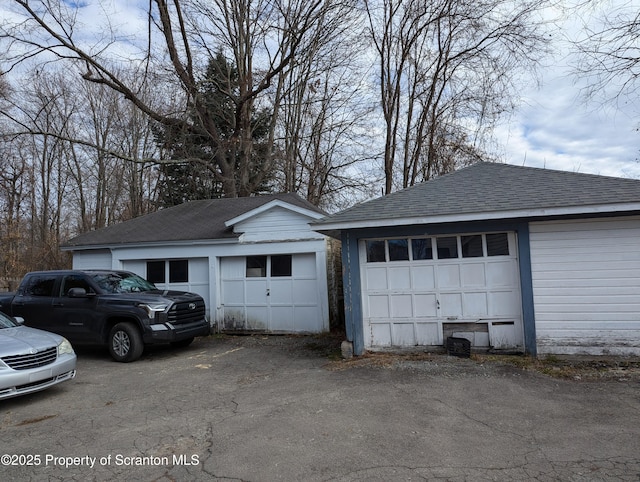 view of home's exterior with a garage and an outbuilding