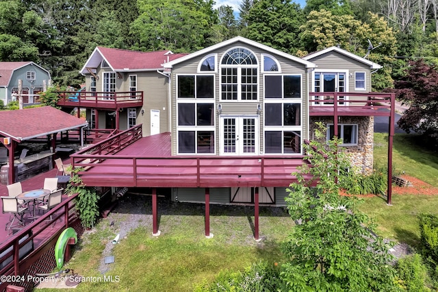 rear view of property with a yard and a wooden deck