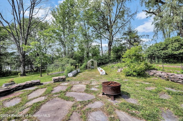 view of yard featuring a fire pit and a storage shed