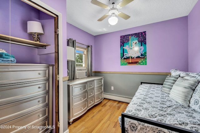 bedroom featuring a textured ceiling, a baseboard radiator, ceiling fan, and light hardwood / wood-style floors