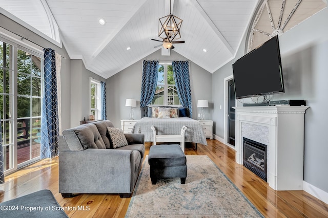 bedroom featuring a chandelier, light wood-type flooring, and vaulted ceiling