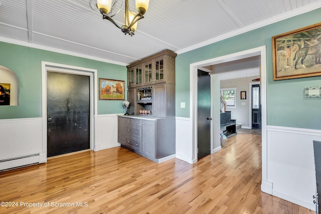 kitchen with pendant lighting, a baseboard heating unit, an inviting chandelier, crown molding, and light hardwood / wood-style floors