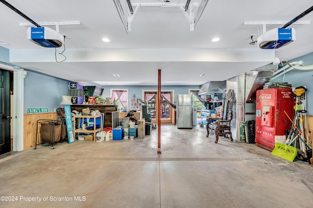 garage featuring a garage door opener and stainless steel refrigerator