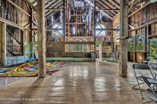 interior space with a high ceiling, hardwood / wood-style flooring, and plenty of natural light