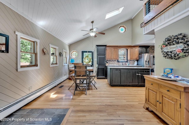 kitchen with backsplash, light hardwood / wood-style flooring, ceiling fan, a baseboard radiator, and stainless steel fridge with ice dispenser