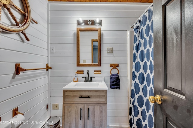 bathroom with vanity, curtained shower, and wooden walls