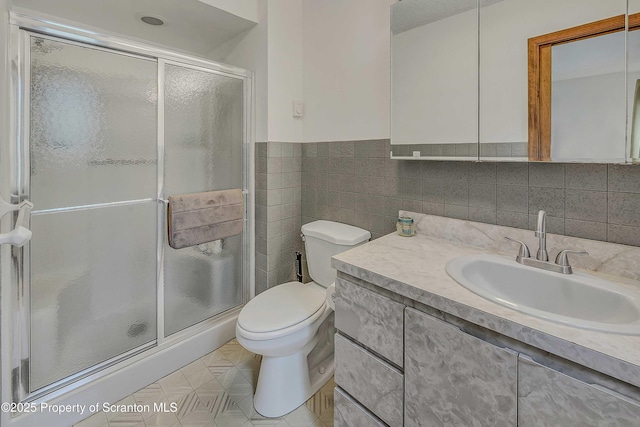 582 Lakeview Dr W, Lake Ariel, PA 18436 - bathroom with toilet, a stall shower, vanity, tile walls, and wainscoting