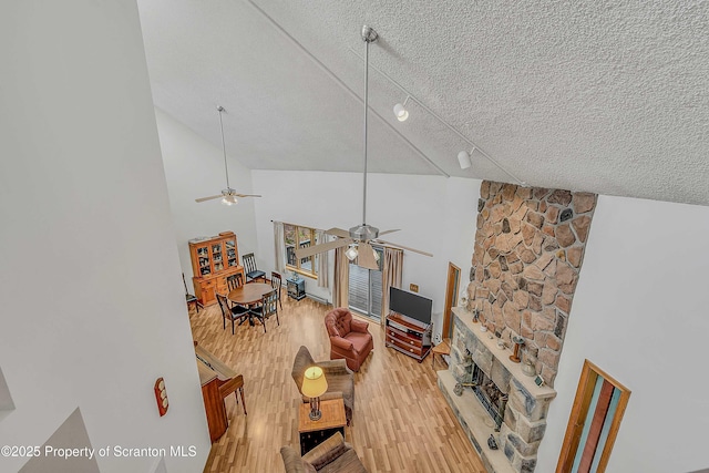 582 Lakeview Dr W, Lake Ariel, PA 18436 - living area with a ceiling fan, a textured ceiling, light wood-style floors, a fireplace, and high vaulted ceiling