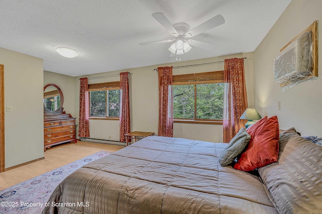 582 Lakeview Dr W, Lake Ariel, PA 18436 - bedroom with multiple windows, a textured ceiling, wood finished floors, a baseboard heating unit, and a ceiling fan