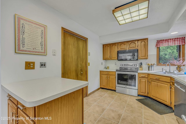 582 Lakeview Dr W, Lake Ariel, PA 18436 - kitchen with appliances with stainless steel finishes, a sink, light countertops, brown cabinetry, and light tile patterned flooring