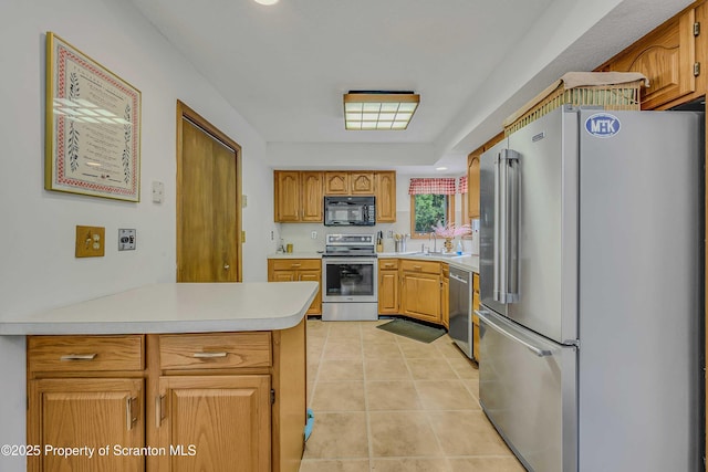 582 Lakeview Dr W, Lake Ariel, PA 18436 - kitchen with appliances with stainless steel finishes, light countertops, a sink, a peninsula, and light tile patterned floors