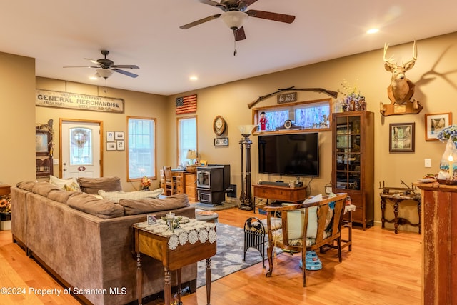 living room with light hardwood / wood-style flooring and a wood stove