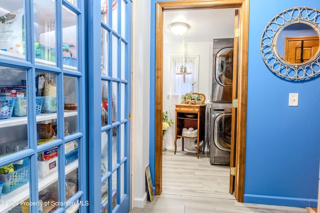 hall featuring light wood-type flooring and stacked washing maching and dryer