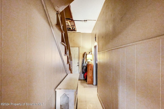 hallway featuring wooden walls