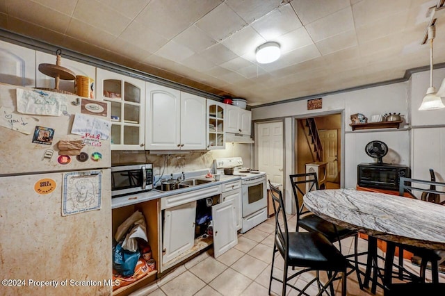 kitchen featuring white cabinetry, sink, decorative light fixtures, white appliances, and light tile patterned floors