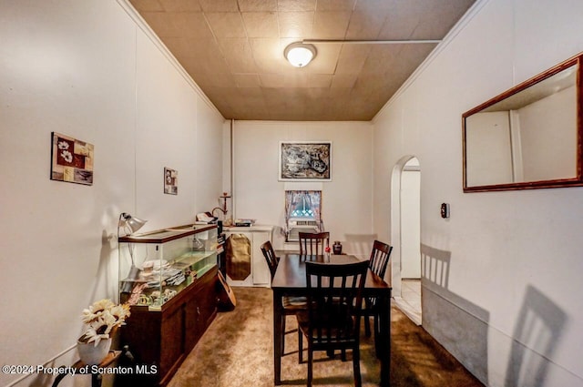 carpeted dining space featuring crown molding