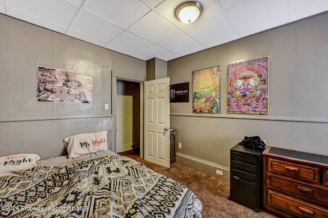 carpeted bedroom with a drop ceiling