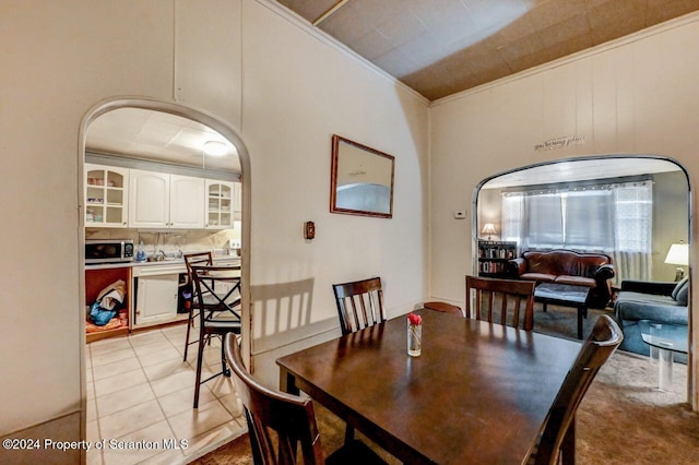 dining space featuring light tile patterned floors and crown molding