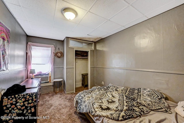 carpeted bedroom featuring a drop ceiling, a closet, and cooling unit