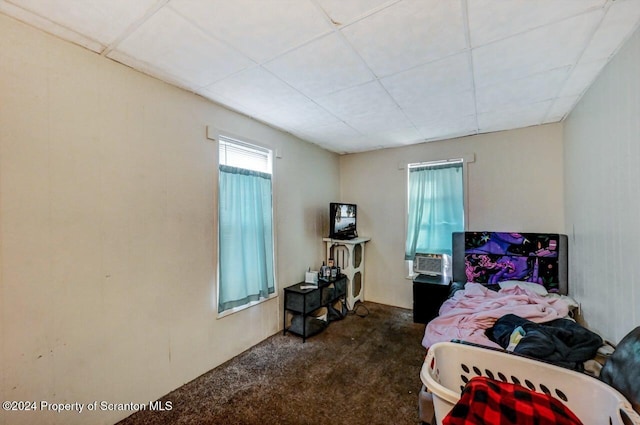 carpeted bedroom with a drop ceiling and cooling unit