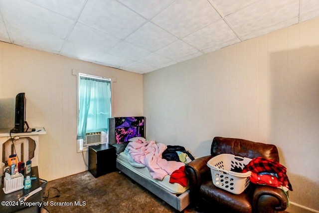 carpeted bedroom featuring a drop ceiling and cooling unit