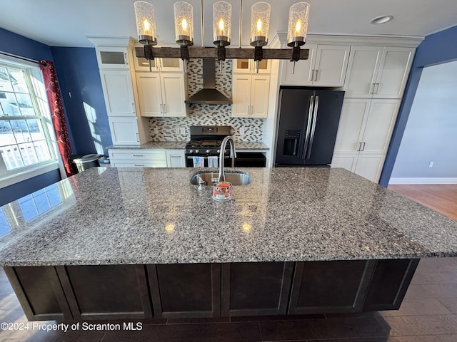 kitchen with pendant lighting, backsplash, wall chimney range hood, a large island, and stainless steel appliances