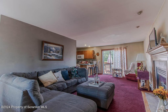 carpeted living room with a tiled fireplace