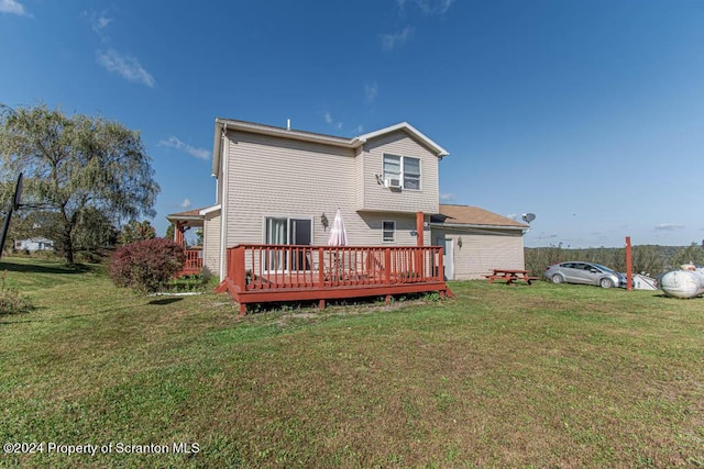 rear view of property featuring a lawn, cooling unit, and a wooden deck