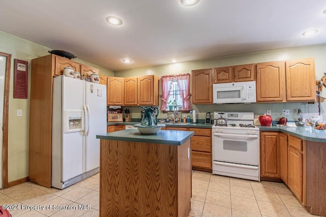 kitchen with a center island, light tile patterned floors, white appliances, and sink