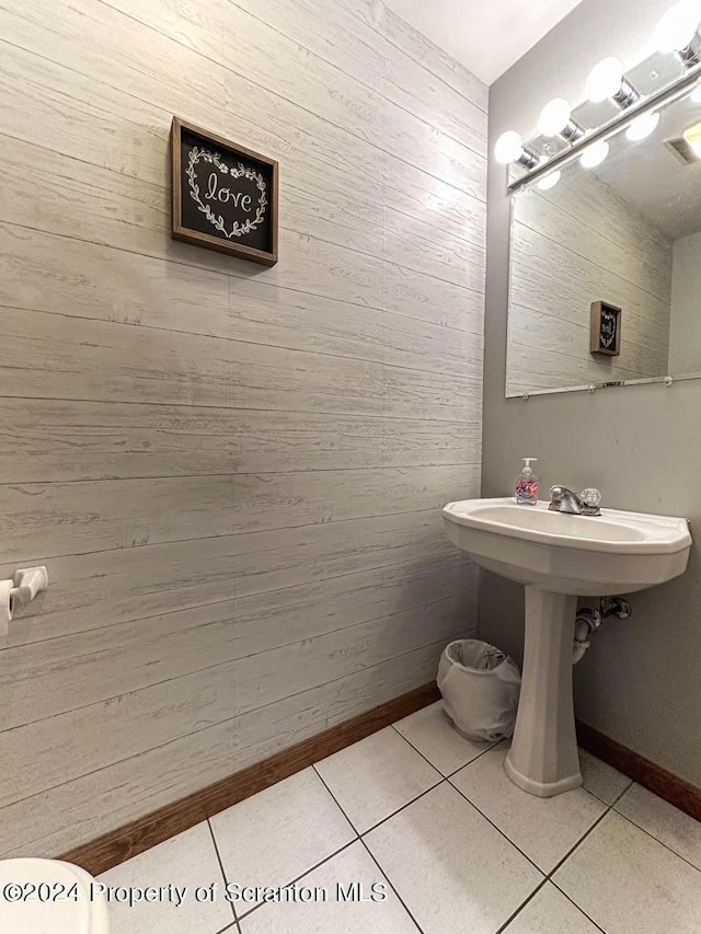 bathroom with wooden walls and tile patterned flooring