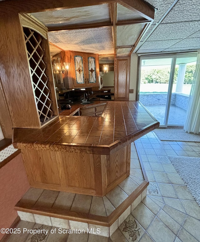 bar with stone tile floors and a sink