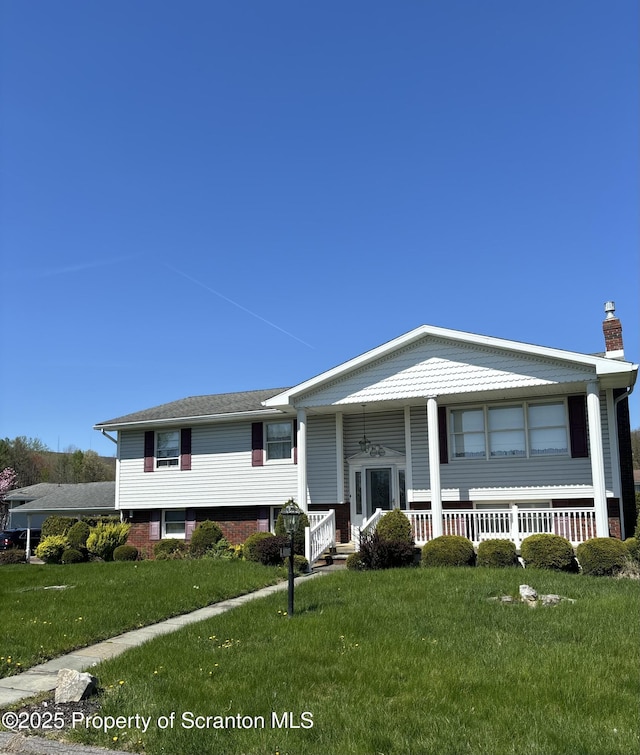 split foyer home with a chimney, a front yard, and a porch