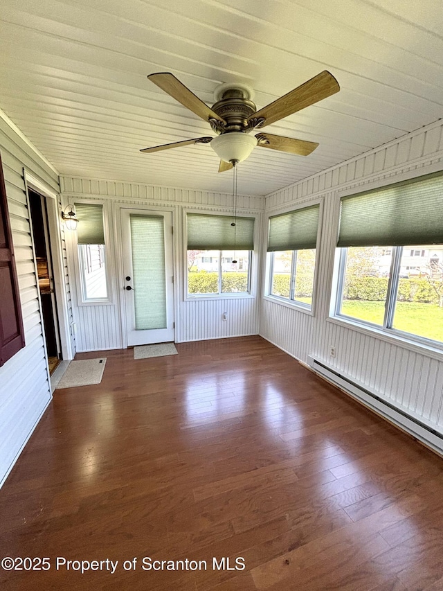 unfurnished sunroom featuring a baseboard radiator and a healthy amount of sunlight