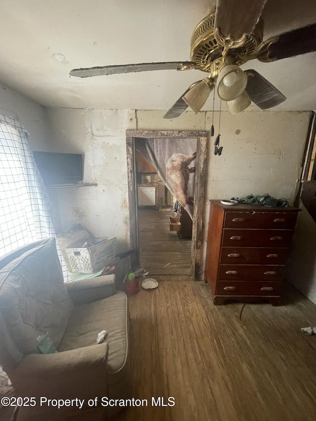 living room featuring dark wood-type flooring and ceiling fan