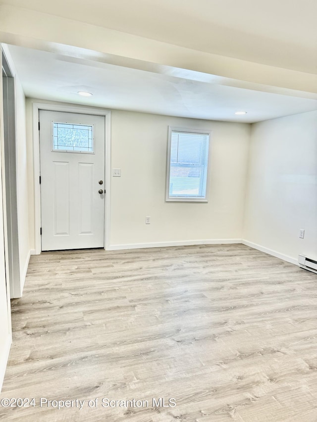 foyer entrance with light hardwood / wood-style flooring and a baseboard heating unit