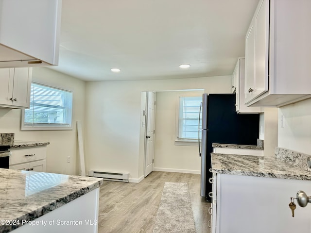 kitchen with white cabinetry, light stone countertops, light hardwood / wood-style flooring, and a baseboard heating unit