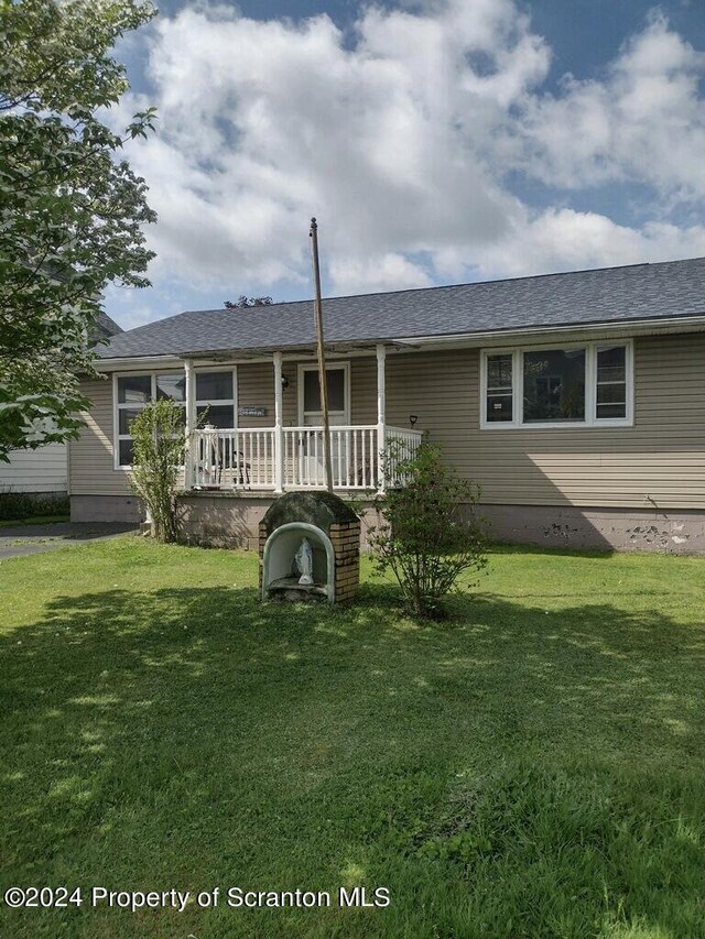 rear view of property with a porch and a lawn