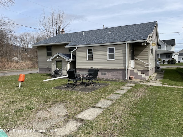 rear view of house featuring a yard and a patio