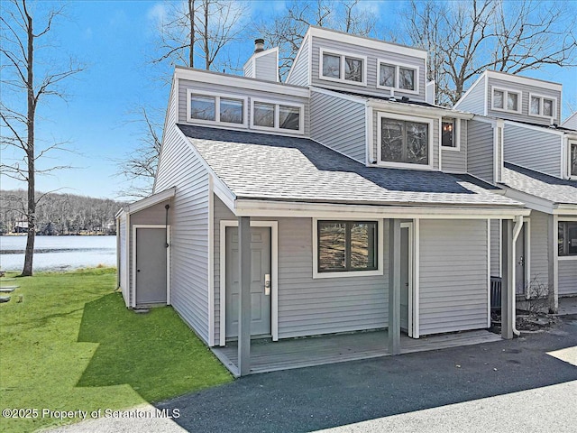 134 Laurel Hill Dr Unit 102, Greentown, PA 18426 - view of front of house featuring roof with shingles, a front yard, a water view, and a chimney
