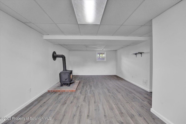 6 Eastview Dr, Scott Twp, PA 18411 - basement with a wood stove, wood finished floors, a drop ceiling, and baseboards