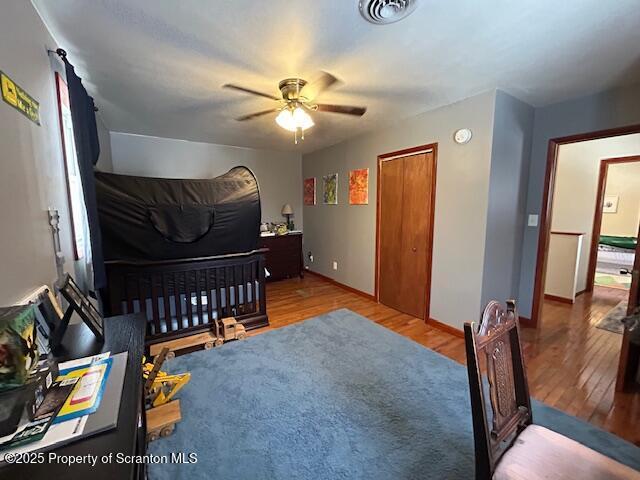 bedroom with ceiling fan, hardwood / wood-style floors, and a closet