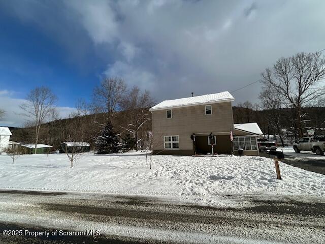 view of snow covered back of property