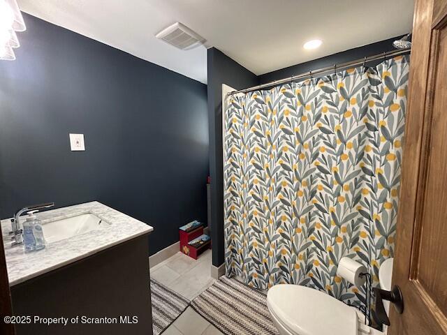 bathroom featuring tile patterned flooring, vanity, curtained shower, and toilet