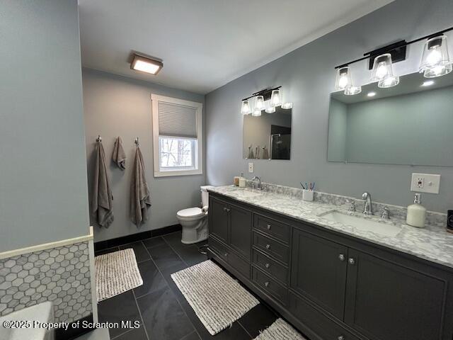 bathroom featuring tile patterned flooring, vanity, and toilet