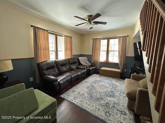 living room with dark wood-type flooring and ceiling fan