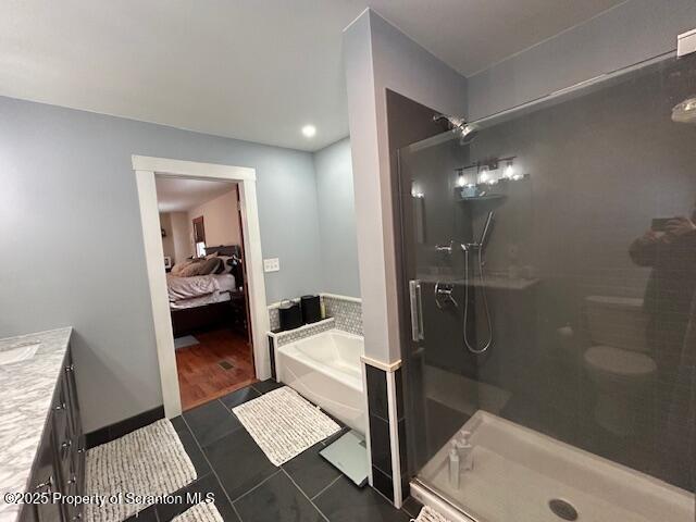 bathroom featuring independent shower and bath, vanity, and tile patterned floors