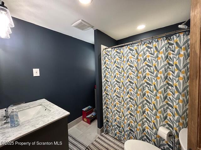 bathroom with walk in shower, vanity, toilet, and tile patterned flooring