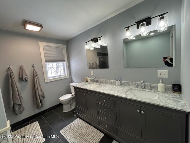 bathroom featuring vanity, tile patterned flooring, and toilet