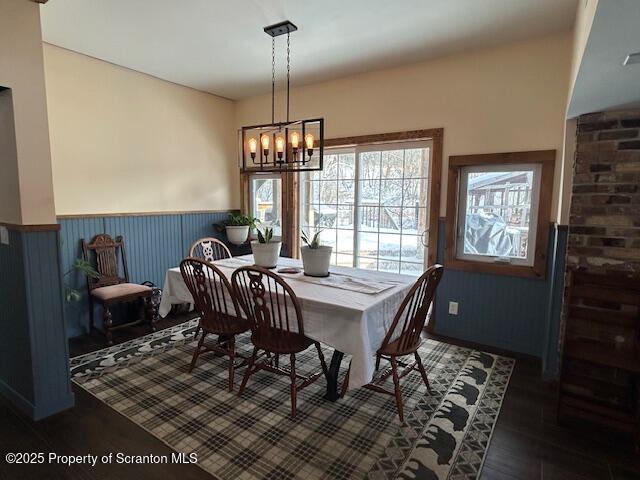 dining area with dark hardwood / wood-style floors and a notable chandelier