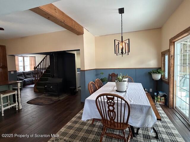 dining room featuring a notable chandelier, dark wood-type flooring, and beamed ceiling